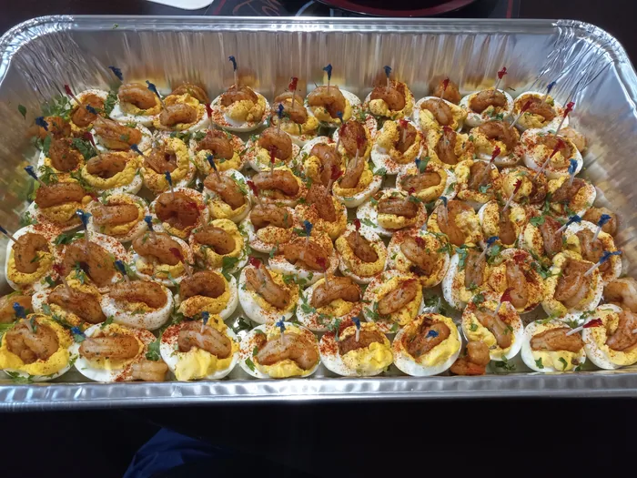 A full tray of deviled eggs dusted with paprika