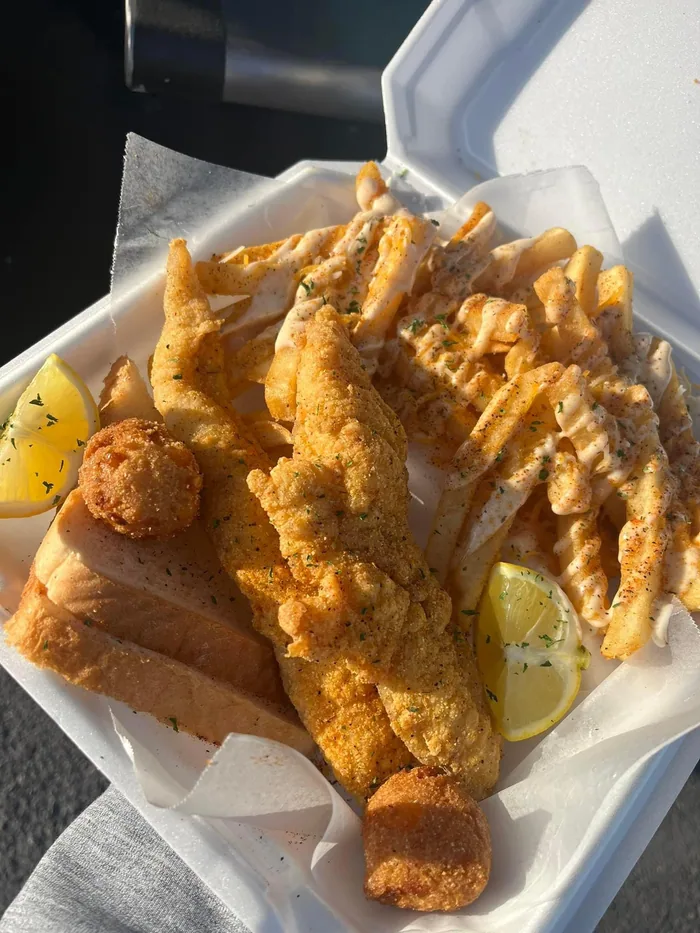 Golden fried fish fillets with crinkle-cut fries and hush puppies