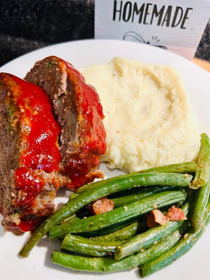 Sliced meatloaf with mashed potatoes and seasoned green beans
