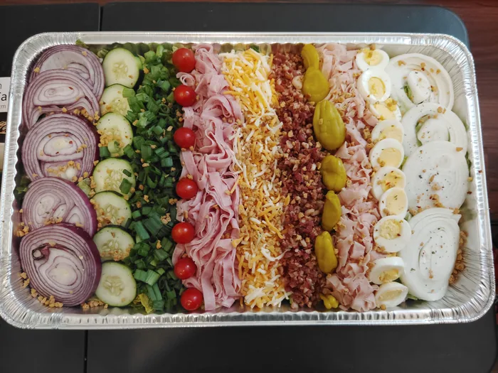 A party tray of deli meats, cheeses and fresh vegetables