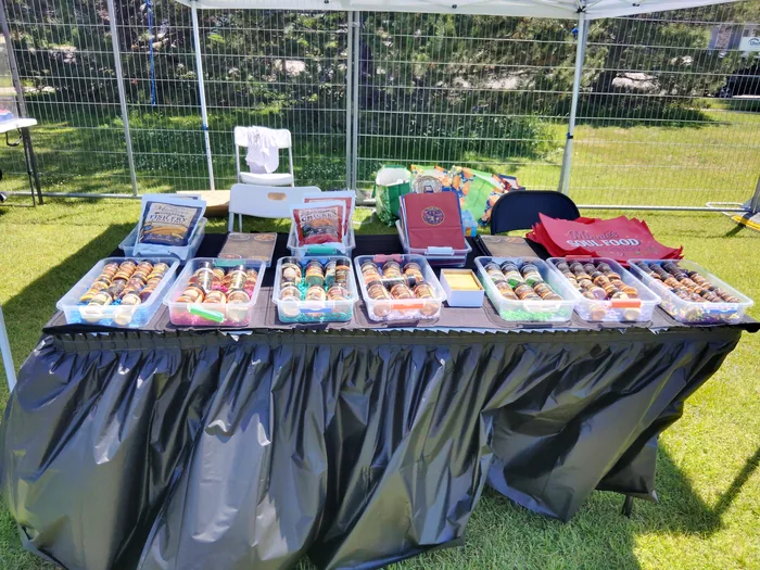 Minnie's seasoning bottles displayed in bins on a table at an outdoor pop-up