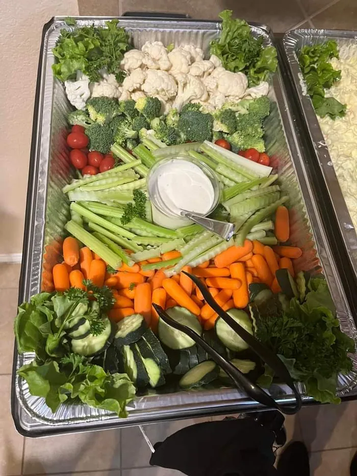 A vegetable tray with celery, carrots, broccoli, cauliflower and dip